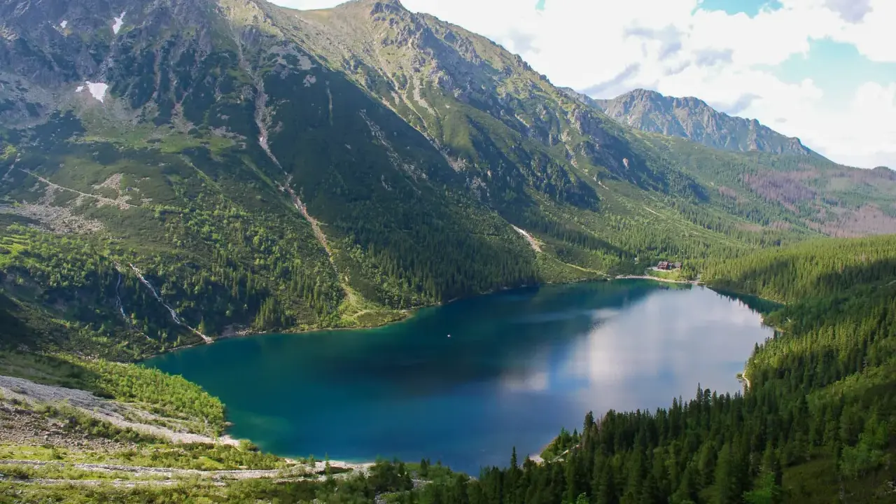 Górskie jezioro Morskie Oko, otoczone zielonymi lasami i skalistymi szczytami, skrywa tajemniczą głębokość.