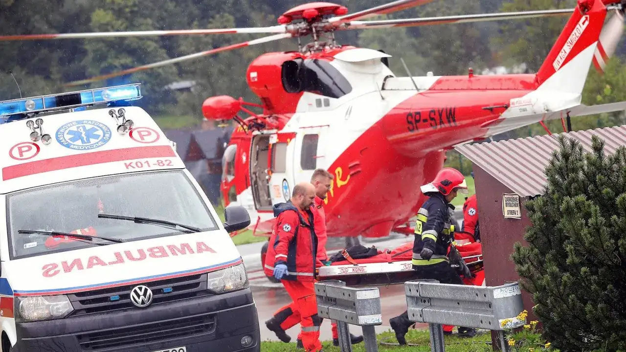 Tragedia w Tatrach. Ratownicy z pogotowia i strażacy niosą nosze obok śmigłowca ratunkowego.