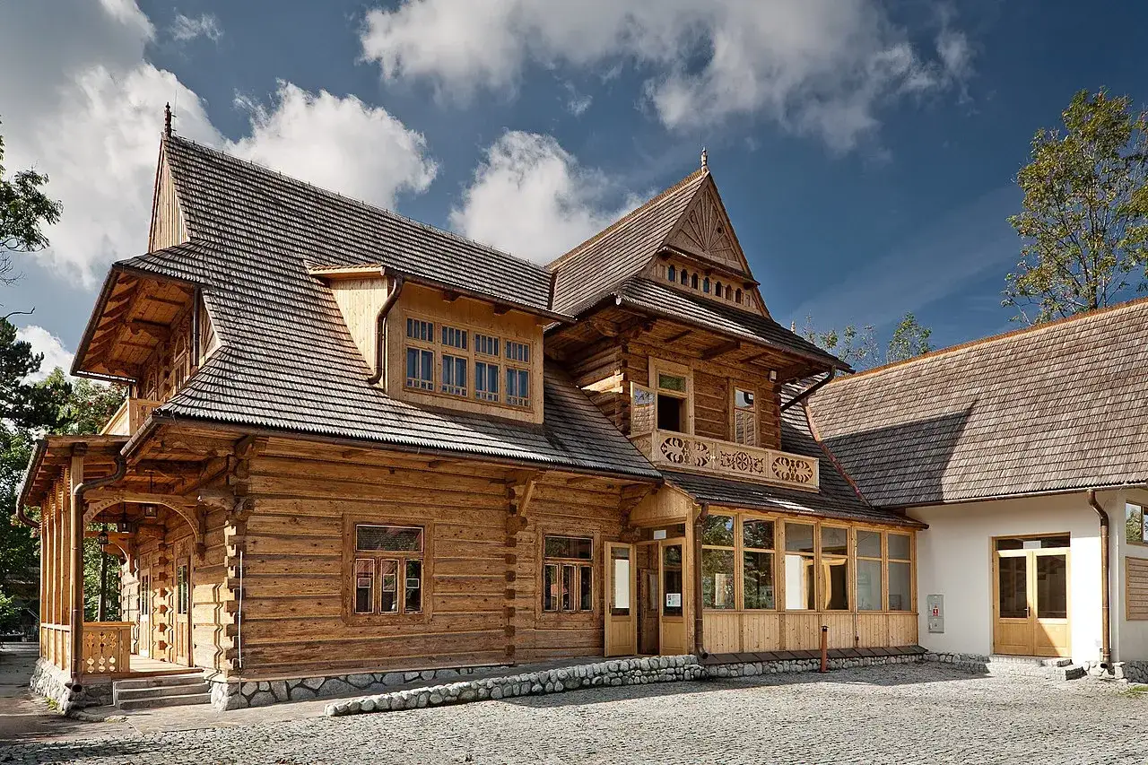 Drewniana willa w stylu zakopiańskim, z charakterystyczną, bogato zdobioną architekturą i kamiennym cokołem.