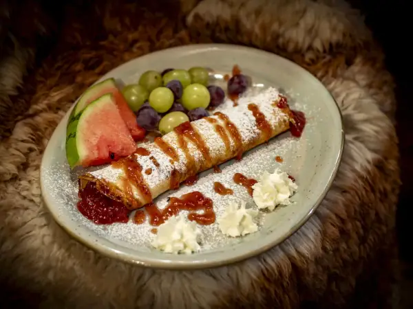 Naleśnik z dżemem, owocami i bitą śmietaną. Idealna propozycja z kuchni góralskiej menu.